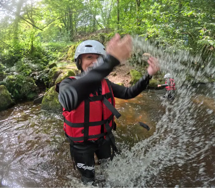 Client souriant en rafting dans le Morvan faisant des éclaboussures sur la rivière Chalaux